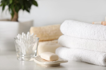 Fototapeta na wymiar Soap bar and towels on white table indoors