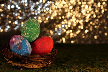 beautiful multicolored Easter eggs in a wicker basket on a shiny background