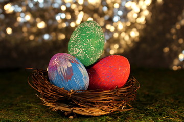 beautiful multicolored Easter eggs in a wicker basket on a shiny background