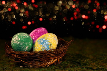 beautiful multicolored Easter eggs in a wicker basket on a shiny background