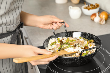 Woman cooking delicious risotto, closeup. Tasty recipe