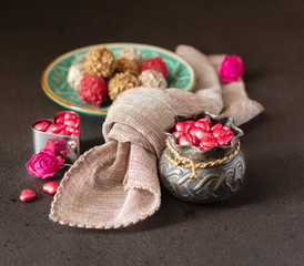 Heart-shaped candies in silver small bowl and chocolate truffles. Valentine's Day concept