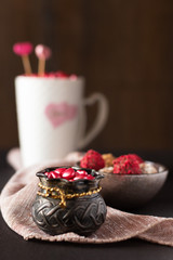 Heart shaped pink candies in small metal bowl and chocolate truffles. Valentine's Day concept.