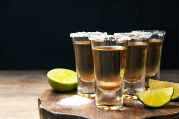 Mexican Tequila shots, lime and salt on wooden table