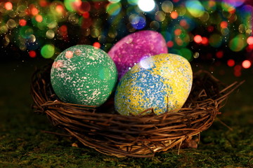 beautiful multicolored Easter eggs in a wicker basket on a shiny background