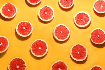 Flat lay composition with tasty ripe grapefruit slices on orange background