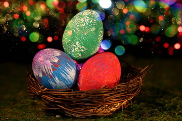 beautiful multicolored Easter eggs in a wicker basket on a shiny background