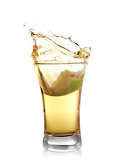Splashing Mexican Tequila in shot glass with lime slice isolated on white