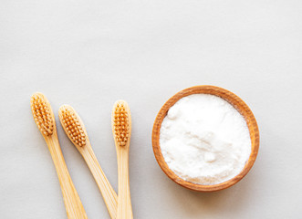 Wooden bamboo eco friendly toothbrushes, baking soda  on white background. Dental care and zero...