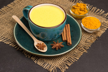 Golden latte with ingredients for cooking: ginger and turmeric powder, turmeric paste, cardamom, cinnamon sticks, star anise. Indian drink turmeric golden milk.