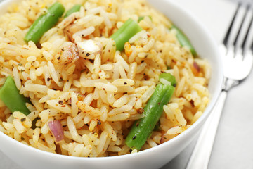 Tasty rice pilaf with vegetables on table, closeup