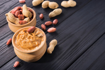 Peanut butter in a bowl on a wooden background