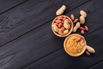 Peanut butter in a bowl on a wooden background
