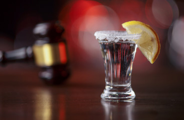 The concept of a DUI. Law hammer, alcohol and car keys on wooden table, dark background