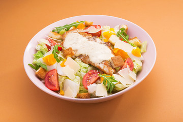 Fresh ceasar salad with vegetables on a color background