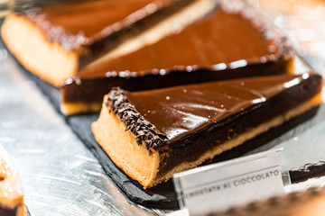 Crostata chocolate pastry tart pie dessert closeup in store window display in gourmet bakery Italian cafe with sign in Florence, Italy market