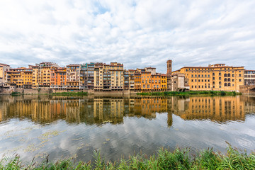 Florence, Italy Firenze orange yellow colorful buildings on Ponte Vecchio by Arno river during summer morning in Tuscany hdr reflection on water