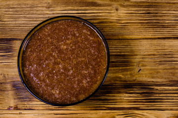 Glass bowl with catfish caviar on wooden table. Top view