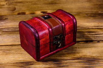 Closed vintage chest from red wood on wooden background