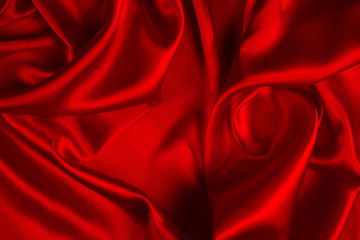 Red silk or satin luxury fabric texture can use as abstract background. Top view.