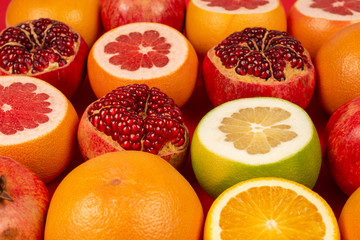 Naklejka na ściany i meble Grapefruit, orange, pomegranate, citrus sweetie on red background.
