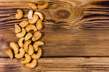 Pile of the roasted cashew nuts on a wooden table. Top view