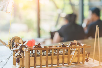 Red heart shaped candle on a turbine baler model made of wooden on table with blur couple in backgound. Valentine day and love concept.