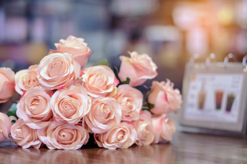 Beautyful bouquet of pink artificial roses placed on the table to decorate the coffee shop.