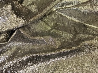fabric draped on the table with folds and iridescent surface, shine, bruise, beams, background