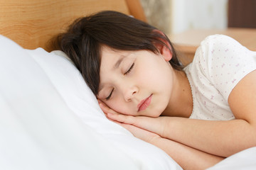 Obraz na płótnie Canvas girl is sleeping on clean white soft bed