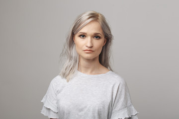 Fototapeta premium Cute young woman in the white clothes posing in the studio