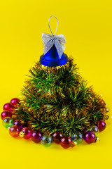 Christmas tree from New Year's tinsel on a yellow background. Merry Christmas and Happy New Year.