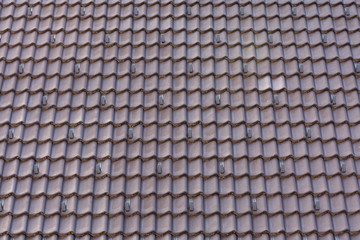 View of the red tiled roof on which hooks are fixed to prevent the avalanche from coming off. Build concept, texture.