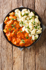 authentic Chicken Paprikash in an unforgettably rich, flavorful and creamy paprika infused sauce closeup on a plate. Vertical top view