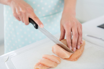 Obraz na płótnie Canvas Cropped closeup photo of housewife hands cutting chicken meat weekend cooking tasty dinner preparation waiting family back home white light kitchen indoors