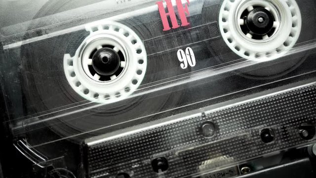 Retro audio tape copmact cassette is playing music.