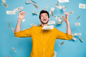 Fototapeta na wymiar Photo of screaming excited emotional guy having won jackpot in lottery smiling toothily isolated over blue pastel color background in yellow shirt