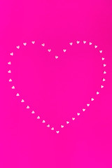 Bright pink background. Pink hearts on a pink background. Hearts sprinkles. Valentine day. Flat lay style. Top view. Place for design. Sweet background. Confetti.