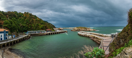 Obraz premium Cudillero harbor wide panorama under cloudy sky