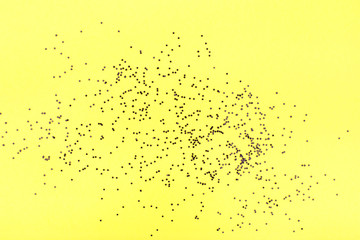 Yellow background with black confetti. Flat lay, copy space, top view. Happy Halloween Card.