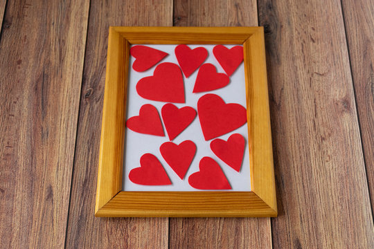 Valentine's day background. Photo frame, gift, heart and red satin ribbon on a wooden background. Valentine's Day, Mother's Day