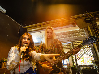 Woman singing, band playing instruments.