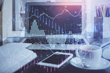 Financial chart drawing and table with computer on background. Double exposure. Concept of international markets.