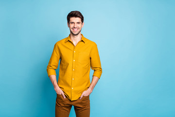 Photo of attractive guy wearing trousers with hands in pockets smiling toothily isolated over vivid pastel color background