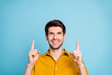 Photo of cheerful attractive handsome man pointing up smiling toothily cheerfully showing way...