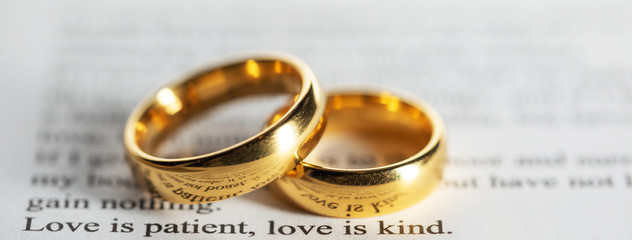 Golden wedding rings on bible book - 315608620