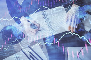 Forex chart hologram on hand taking notes background. Concept of analysis. Multi exposure