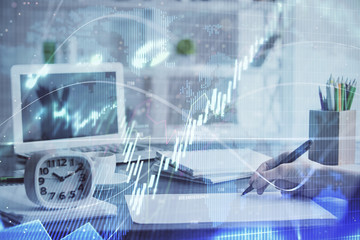 Financial graph displayed on woman's hand taking notes background. Concept of research. Multi exposure