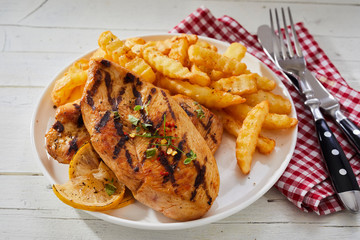 Serving of BBQ chicken breast with potato chips