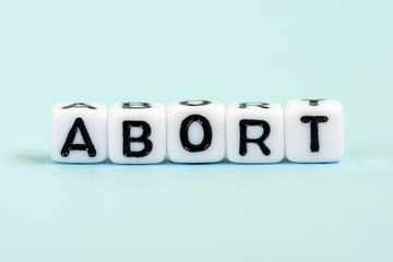 Abort word written on cubes. Medical blue background